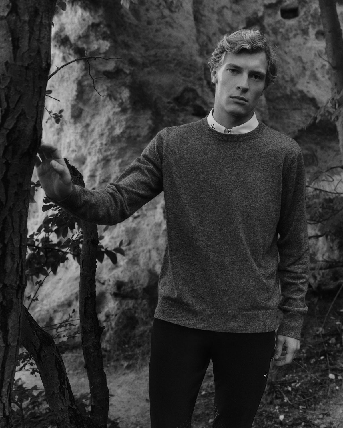 A model in a crew-neck knit among the trees at Faxe Kalkbrud, photographed in black and white.